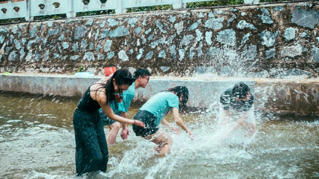 家长带孩子在溪流中玩水